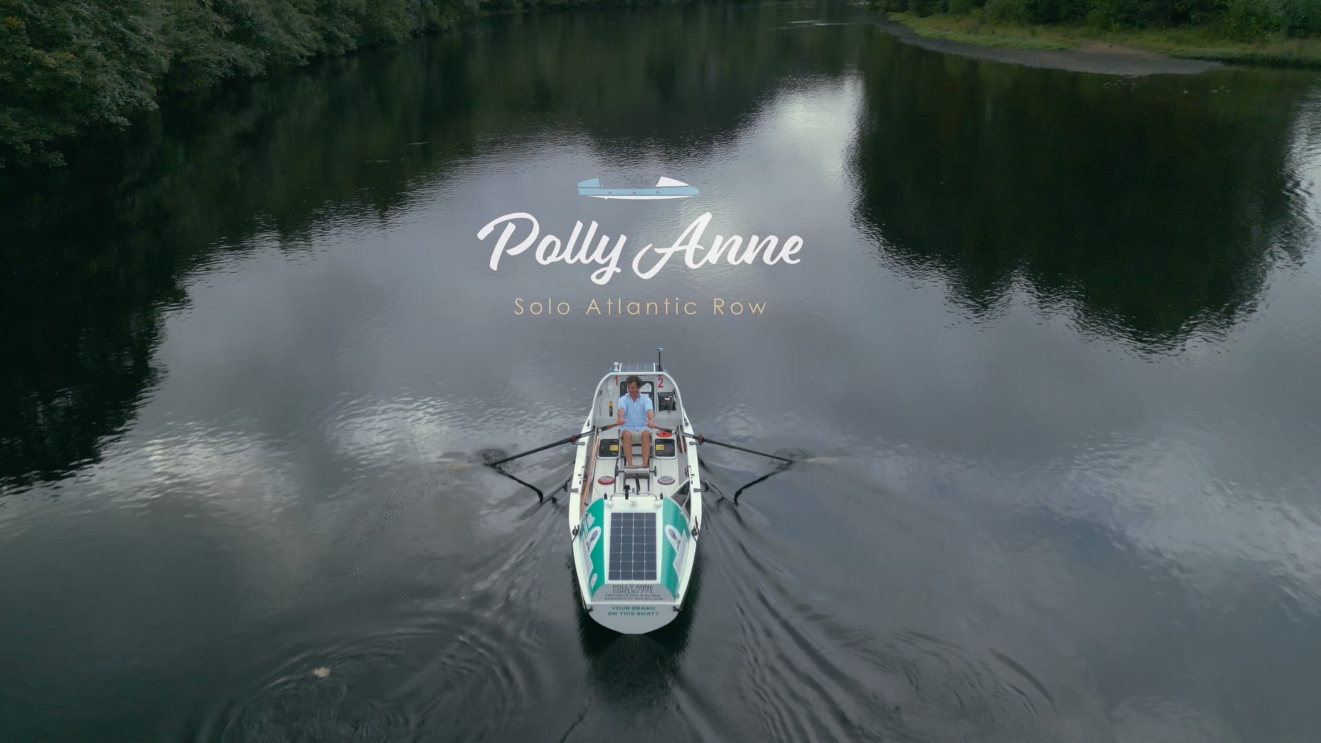 A solo ocean rowing boat on calm water seen from above, titled Polly Anne, Solo Atlantic Row.